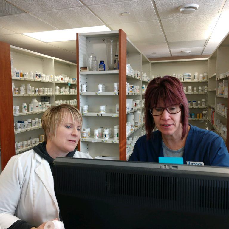 Two women at a pharmacy looking at computer screen