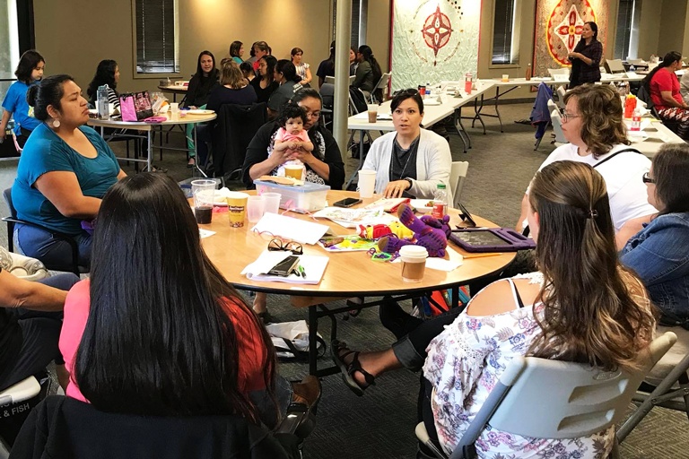 Natalie Nicholson at a table talking with other Native women